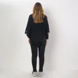 Poncho gris con flecos en el borde inferior, cuello alto y corte asimétrico.