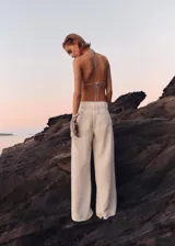 Pantalón largo blanco de tiro medio, diseño de corte recto y confeccionado en 100% algodón, con bolsillos laterales y traseros, cierre de cremallera y botón.