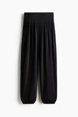 Pantalón negro de tiro alto confeccionado en punto interlock pesado. Cuenta con cintura elástica con pliegues cosidos alrededor, diseño de piernas barrel y puños elásticos ceñidos en los tobillos.