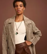 Suéter de punto acanalado color beige, con cuello redondo y mangas largas. Confeccionado en tejido tricot con textura suave y ajuste al cuerpo.