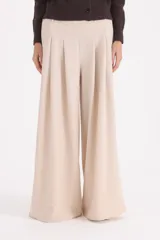 Pantalon de corte ancho y tiro alto, con pinzas frontales que aportan volumen y caída fluida.