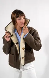 Campera gamulán reversible de cuero color habano con interior de corderito sintético. Presenta cuello solapa, cierre frontal con botones y bolsillos laterales.