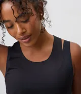 Musculosa deportiva Get Over en microfibra negra, de calce suelto, con escote redondo y perforaciones láser para ventilación.