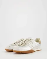 Championes de estilo retro con acabado metalizado plateado, detalles en cuero color crema y suela de goma color caramelo. Presentan cordones al tono y refuerzo en el talón.