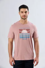 Remera blanca de manga corta y cuello redondo, con estampa frontal inspirada en el mar y atardeceres de verano con la inscripción 'Travel. Beach. Repeat.' y 'Legacy'.