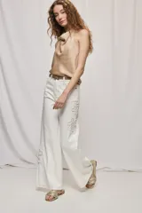 Jean wide leg blanco de tiro medio, con calce amplio y detalle de flores bordadas en los laterales.