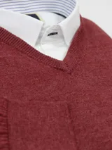 Sweater celeste de hilo con escote en V y logo bordado en el frente.