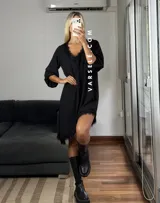 Vestido corto color bordó, con escote en V y detalles de encaje en el cuello y el dobladillo asimétrico. Tiene mangas tres cuartos y un corte holgado.