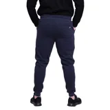 Pantalón de jogging azul marino con cintura elástica ajustable mediante cordón, bolsillos laterales y puños en los tobillos. Presenta un pequeño logo bordado en color blanco en la pierna izquierda.