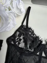 Corset negro de encaje floral y transparencias con portaligas ajustables y tanga a juego.
