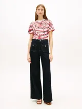 Remera Tommy Hilfiger de corte regular confeccionada en puro algodón con punto interlock. Presenta un diseño de rayas horizontales rojas y blancas con estampado floral gráfico superpuesto, cuello redondo y mangas cortas.