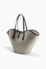 Bolso tipo shopper de tela color beige con diseño geométrico y detalles en cuero sintético negro. Tiene doble asa de mano y cierre superior con detalle metálico dorado.