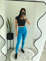 Conjunto deportivo azul con textura acanalada, compuesto por calzas largas de tiro alto y top deportivo con breteles anchos.