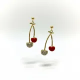 Aros colgantes con diseño de cerezas, confeccionados en acero dorado. Una de las cerezas presenta un acabado esmaltado en color rojo vibrante, mientras que la otra está decorada con strass brillante.