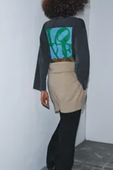 Camiseta de manga larga, corte regular, color negro con efecto lavado o acid wash. Presenta un estampado frontal en rojo con la palabra "LOVE" estilizada.