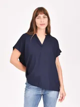 Blusa azul marino de corte holgado, con cuello en V y mangas cortas.