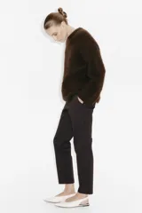 Pantalón tobillero de color marrón oscuro, corte recto y ajustado, con cintura estándar y bolsillos al bies.