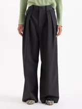 Pantalón de vestir de corte sastrero, con silueta de pata ancha y tiro alto. Presenta un elegante tableado en la cintura delantera, cierre metálico con ganchos y bolsillos laterales y traseros.