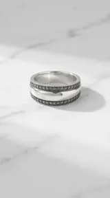 Anillo de plata 925 con diseño bombe, presenta una banda central lisa pulida flanqueada por dos hileras de marquesitas incrustadas.