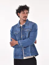 Campera de jean azul con cuello clásico, cierre frontal con botones metálicos, bolsillos con solapa abotonada en el pecho y bolsillos laterales.