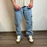 Pantalón jean cargo gris con efecto lavado, corte recto y bolsillos laterales.