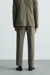 Pantalón de vestir regular fit confeccionado en tejido con lana, con bolsillos frontales y traseros de doble vivo con botón, cierre frontal con cremallera y botón.