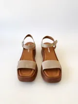 Sandalias con plataforma color beige, con tira ancha sobre los dedos y tira con hebilla al tobillo.