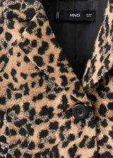 Chaqueta corta de corte recto con estampado de leopardo, cuello camisero, manga larga, bolsillos delanteros de parche y cierre frontal con botones.