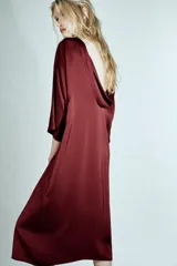 Vestido midi de Zara Woman Collection confeccionado en viscosa satinada, color bordó. Presenta cuello barco, mangas por debajo del codo y bajo recto, con detalle de lazo fino en la parte posterior del cuello.