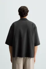 Camisa de corte relajado confeccionada en tejido mezcla de lyocell, con cuello solapa, manga corta y cierre frontal con botonadura oculta.