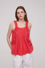 Musculosa roja de algodón con breteles finos, volados en los breteles y frunces en el frente.