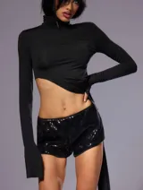 Top negro de manga larga con cuello alto y abertura lateral en la cintura.