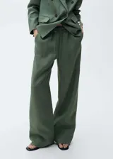 Pantalón de lino color verde militar, de corte recto y tiro medio. Presenta cintura elástica con cordón ajustable, bolsillos laterales y forro interior de algodón.