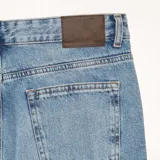 Pantalón de jean celeste de corte recto, con tiro medio y bolsillos delanteros y traseros.
