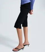 Pantalón capri de corte ajustado, confeccionado en bengalina, con diseño básico y liso.