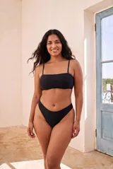 Top de bikini bandeau color negro con tirantes finos regulables.