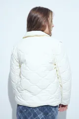 Campera acolchada de color negro con diseño capitoneado, cierre frontal con botones y cuello clásico.