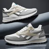 Championes deportivos de estilo retro, combinando malla blanca, gamuza gris y detalles en beige y negro. Suela gruesa blanca con capas grises y detalles dorados.