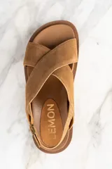 Sandalias bajas color marrón de gamuza, con tiras cruzadas en el empeine, tira trasera con hebilla y suela de goma.