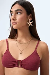 Top de bikini azul con textura fruncida y detalle de aro al frente. Posee breteles finos regulables y un calce cómodo que realza el busto con un toque moderno.