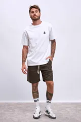 Bermuda color beige con bolsillos cargo laterales y cordón ajustable en la cintura.