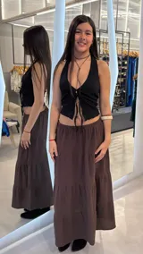 Pollera larga de tiro bajo en color marrón, con diseño de paneles escalonados y caída fluida.