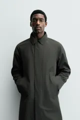 Gabardina impermeable de corte regular fit en color verde militar, con cuello solapa, manga larga con puño ajustable con botones a presión y bolsillos de vivo en la cadera. Cierre frontal con cremallera oculta por solapa con botones a presión.