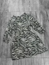 Vestido corto con estampado de cebra, mangas 3/4 y corte holgado.