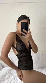 Body de encaje negro con escote pronunciado en V, breteles regulables y diseño entallado.