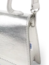 Cartera tipo bandolera pequeña, color plateado metalizado, con solapa superpuesta y correa fina ajustable.