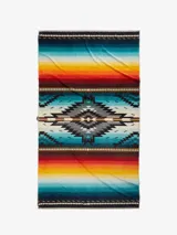 Toalla extragrande de felpa suave con un lado aterciopelado y diseño de bucles para absorción superior. Presenta un patrón geométrico central en tonos grises y negros, flanqueado por franjas horizontales de colores vibrantes como turquesa, rojo, naranja y amarillo.