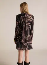 Vestido corto de diseño evasé con cuello alto drapeado y manga larga. Confeccionado en tejido fluido con acabado satinado y estampado animal print de cebra en tonos marrones y negros. Incluye forro interior y cierre de cremallera en la parte posterior.