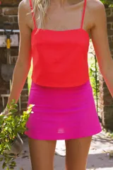 Minifalda rosa confeccionada en lino y rayón, de tiro medio alto y corte recto.