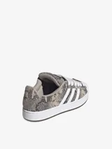 Zapatillas Adidas Superstar ST con exterior de diseño texturizado símil animal print de serpiente en tonos grises y tostados, combinados con las icónicas tres tiras blancas, cordones anchos y la clásica puntera de caucho en color blanco.